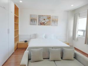 a white bedroom with a large white bed with pillows at Juna hotel - Condotel in Thanh Hóa +29 photos