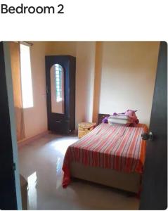 a bedroom with a bed with a pile of clothes on it at Sir Residency in Howrah