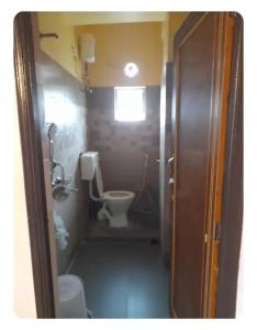 a small bathroom with a toilet and a sink at Sir Residency in Howrah