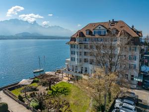 a large building next to a large body of water at Hotel Restaurant Bellevue au Lac in Thun