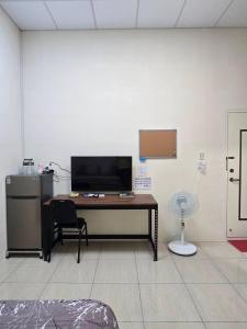 an office with a desk with a chair and a fan at 南田旅宿親子商務 in Fengyuan +86 photos