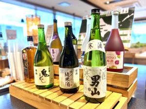 four bottles of wine sitting on a wooden shelf at Super Hotel Ishikari in Ishikari