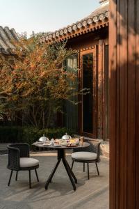a table and chairs with food on it on a patio at Mandarin Oriental Qianmen, Beijing in Beijing