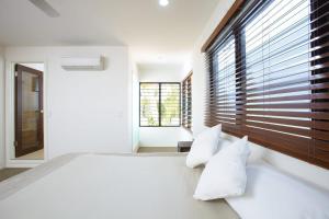 a bedroom with a large bed with white pillows at Beached on Magnetic in Picnic Bay