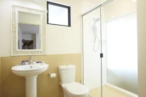 a bathroom with a toilet and a sink and a shower at Beached on Magnetic in Picnic Bay