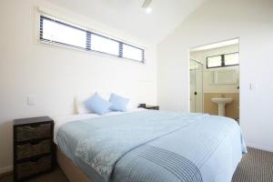 a white bedroom with a large bed and a window at Beached on Magnetic in Picnic Bay +8 photos