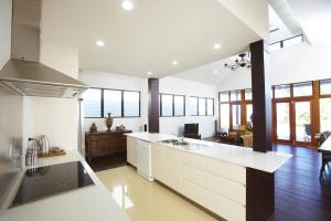 a large kitchen with white cabinets and a counter top at Beached on Magnetic in Picnic Bay
