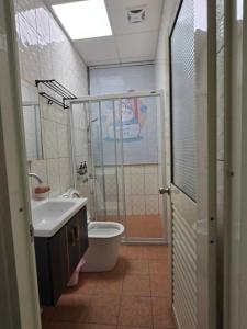 a bathroom with a shower and a toilet and a sink at 南田旅宿親子商務 in Fengyuan