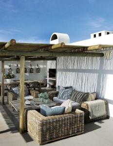 un patio con sofás y una pérgola en Malindila Apartment & House, en Langebaan