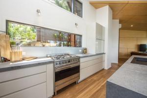a kitchen with a stove and a large window at Headland House in Picnic Bay +10 photos