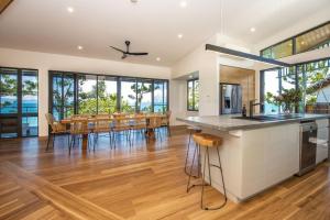 a kitchen and dining room with a table and chairs at Headland House in Picnic Bay