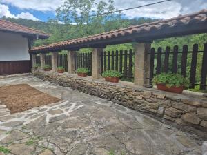 a stone fence with potted plants on a patio at Къща Цачеви 2 in Tryavna