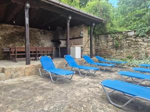 a group of blue chairs in front of a stone building at Къща Цачеви 2 in Tryavna +8 photos