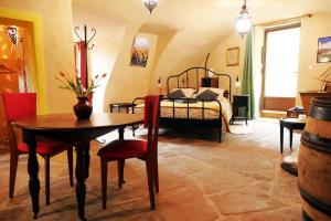 a room with a bed and a table and chairs at Chambre d'Hôtes La Chadeleufade in Chadeleuf
