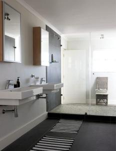 a bathroom with two sinks and a glass shower at Malindila Apartment & House in Langebaan