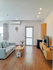 a living room with a couch and a table at Juna hotel - Condotel in Thanh Hóa
