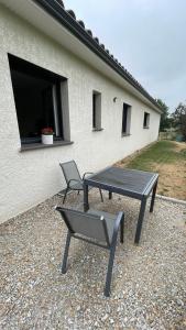 a picnic table and a chair in front of a building at Chez Cathie & Didier in Revel