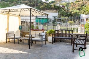 a group of chairs and tables under an umbrella at Hotiday Ponza Scogliera in Ponza