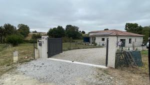 a gate in front of a house with a building at Chez Cathie & Didier in Revel