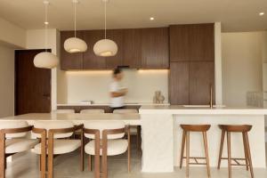 a kitchen with a counter and a table and chairs at Fira Uluwatu in Uluwatu