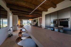 a kitchen with a long wooden table and chairs at Dimora Riccio in Dalegna del Collio
