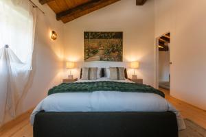 a bedroom with a large bed with a painting on the wall at Dimora Riccio in Dalegna del Collio
