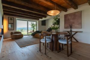 a living room with a table and chairs and a couch at Dimora Riccio in Dalegna del Collio +10 photos