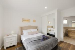 a bedroom with two beds and a mirror at Ralph Escapes Kingsley in Perth