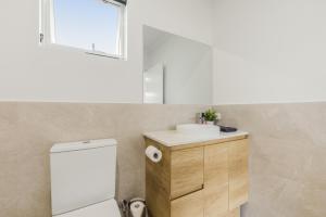 a bathroom with a sink and a toilet and a window at Ralph Escapes Kingsley in Perth +8 photos