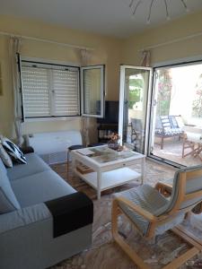 a living room with a couch and a table at Lagonissi Summer House in Lagonissi