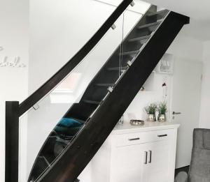 a staircase with black railings and a kitchen under it at Sonnendeck 36 - Großenbrode in Grossenbrode +26 photos