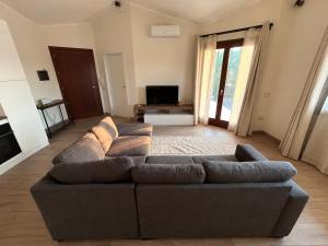 a living room with a couch and a television at Casa Tanca Marchese in Marrùbiu