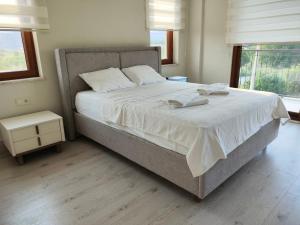 ein Schlafzimmer mit einem großen Bett mit weißer Bettwäsche in der Unterkunft Pronaos in Ortaca + 62 Fotos