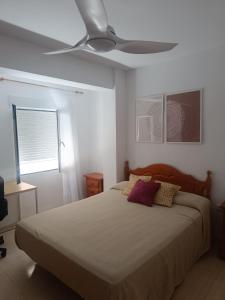 a bedroom with a bed with a ceiling fan at Apartamento Junto AL MAR Quesada 2 in Almería