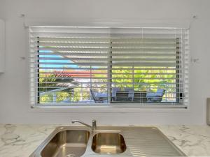 a kitchen sink in front of a window with blinds at Magnetic Haven Unit 5 in Arcadia +22 photos