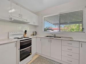 a white kitchen with white cabinets and a sink at Magnetic Haven Unit 5 in Arcadia