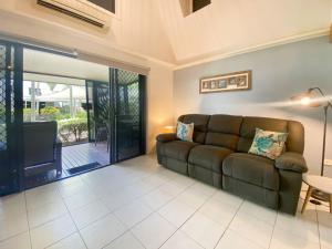 a living room with a couch and a television at Canopy Chalet 4 in Nelly Bay +14 photos