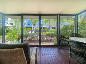 a screened in porch with a table and chairs at Canopy Chalet 4 in Nelly Bay