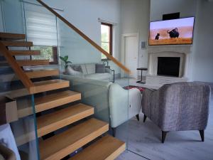 Ein Wohnzimmer mit Treppe und einem Fernseher an der Wand in der Unterkunft Pronaos in Ortaca