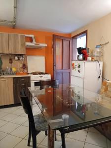 a kitchen with a glass table and a white refrigerator at Guest House Sun in Kranevo