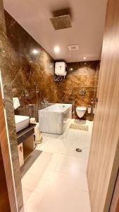 a bathroom with a tub and a toilet and a sink at Hotel MEDHA Inn in Patna +16 photos