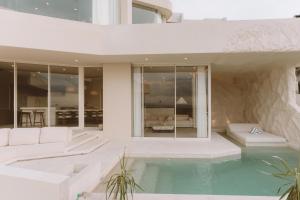 a living room with a swimming pool and a house at Fira Uluwatu in Uluwatu