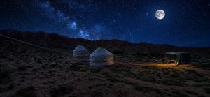 two tents in a field at night with the moon at Kyzyl-Jar in Kaji-Say