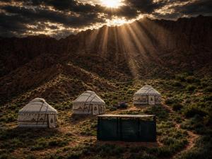 three gazebos in a field with the sun shining at Kyzyl-Jar in Kaji-Say