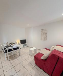 a living room with a red bed and a table at Les studios du Général - Lavande in Saint-Maximin-la-Sainte-Baume