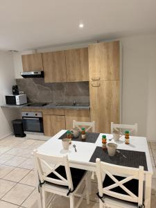 a kitchen with a white table and chairs in it at Les studios du Général - Lavande in Saint-Maximin-la-Sainte-Baume