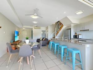 a kitchen and living room with a table and chairs at Beachside Apartment 14 in Nelly Bay