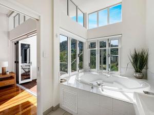a large white bathroom with a tub and windows at Beachside Apartment 14 in Nelly Bay +11 photos