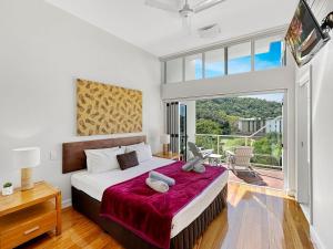 a bedroom with a large bed and a large window at Beachside Apartment 14 in Nelly Bay
