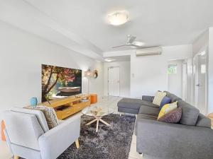 a living room with two couches and a tv at Beachside Apartment 14 in Nelly Bay